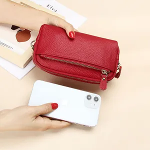 Red pebbled leather double zipper wallet shown next to a smartphone for size comparison