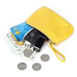Monedero de cuero amarillo con cremallera y asa que muestra capacidad para las llaves