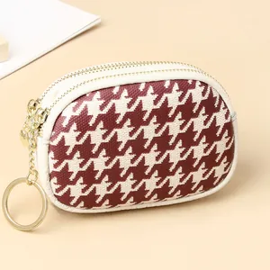 Détail du porte-monnaie en cuir pied-de-poule rouge avec double zip et porte-clés