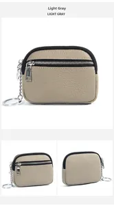 Detail view of light gray genuine leather coin purse with triple zippers and keychain