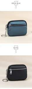 Detailed view of dual zipper leather coin purses in denim blue and black with keyrings