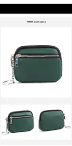 Detail view of dark green genuine leather coin purse with double zippers and metal keychain