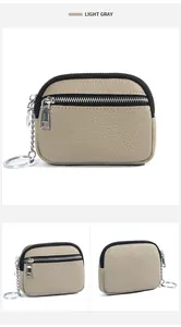 Detailed views of light gray pebbled leather coin purse with silver metal zippers and keyring