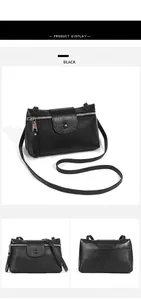 Detail view of black lychee grain leather crossbody bag with metal zipper and magnetic snap