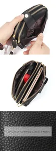 Internal view of black leather wallet with triple zippers and multiple compartments