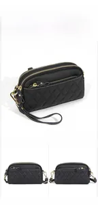 Detail of black pebbled leather crossbody bag with quilted rhombic pattern and gold zippers
