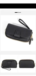 Detail of black pebbled leather long wallet with double zippers and gold hardware features