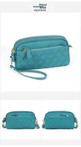 Detail of aqua blue quilted leather handbag with triple zipper pockets and lychee texture