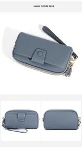 Detail view of denim blue lychee grain leather wallet with golden hardware and wrist strap