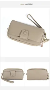 Detailed view of light gray litchi grain leather wallet with golden hardware and wrist strap