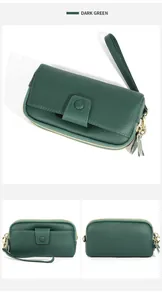 Detail of dark green pebbled leather wallet featuring double zippers and a wristlet strap
