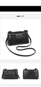 Detail of black lychee grain leather crossbody bag showing metal zipper and texture