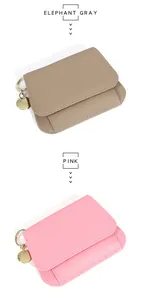 Détail de portefeuilles en cuir grainé gris éléphant et rose avec porte-clés dorés