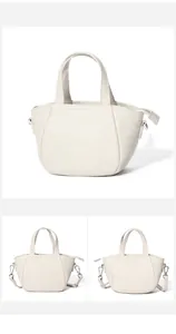 Detalle de bolso en cuero blanco crema con asas dobles y herrajes metálicos de calidad