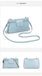 Detail of aqua blue leather crossbody bag showing lychee grain texture and metal zipper