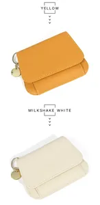 Détail de portefeuilles en cuir grainé jaune et blanc crème avec anneau de clé doré