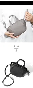 Detalle del bolso bandolera de piel granulada en opciones de color gris y negro
