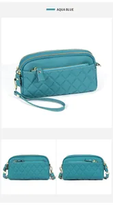 Detailed view of aqua blue quilted leather crossbody bag with triple zipper compartments