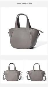 Detalle del bolso de piel graneada gris elefante con bandolera ajustable y asa