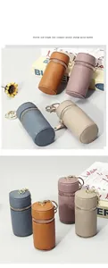 Détail de mini étuis cylindriques en cuir véritable avec fermeture éclair et texture