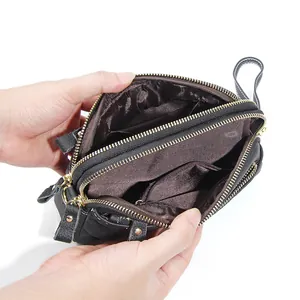 Genuine leather crossbody bag featuring three zipper layers and textured black finish