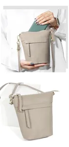Detail der taupefarbenen Leder-Beuteltasche mit Handy zeigt den Stauraum