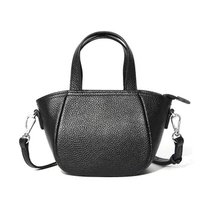 Bolso de mano minimalista en cuero negro con motivo de lichi y bandolera ajustable