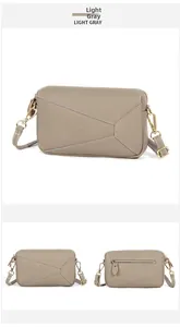 Detail view of light gray genuine leather crossbody bag with geometric puzzle stitching