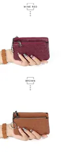 Detail view of woven sheepskin coin purses in wine red and brown with metal chains