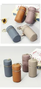 Vue détaillée de quatre mini pochettes cylindriques en cuir avec fermetures éclair dorées