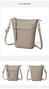 Details der hellgrauen Eimer-Tasche aus Kieselleder mit Goldreißverschluss und Nähten