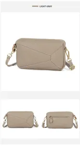 Detail view of light gray puzzle bag with geometric pattern and golden hardware