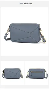 Detail view of denim blue lychee grain cowhide bag with geometric stitching and gold hardware