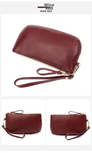 Detail view of wine red pebbled leather long wallet with wrist strap and metal zipper