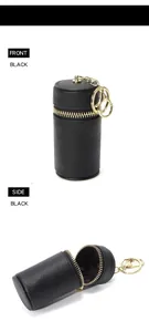 Détail d'une mini pochette en cuir grainé noir avec fermeture éclair dorée et anneau