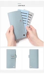 Détail du porte-cartes en cuir bleu clair montrant les fentes et le bouton pression