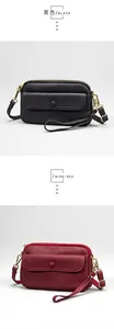 Detail of leather crossbody bags in black and wine red with gold hardware and zippers