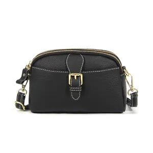 Minimalistische schwarze Leder-Umhängetasche mit weißen Nähten und zwei Reißverschlüssen
