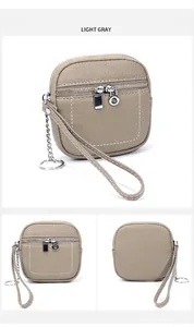 Dettaglio mini portamonete in pelle grigio chiaro con doppia zip e anello portachiavi