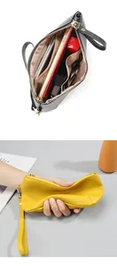 Detailed view of spacious leather clutch interior and soft textured finish with wrist strap