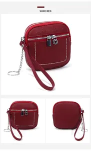 Vista dettagliata del portamonete in pelle bordeaux con doppia zip e cinturino