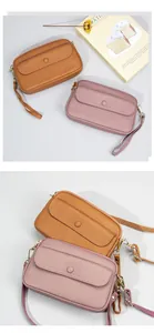 Detail view of brown and pink leather crossbody bags with gold hardware and strap
