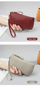 Close-up of pebble grain leather texture on wine red and beige long wristlet wallets