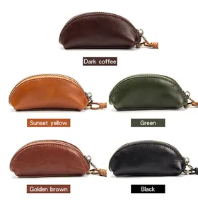 Dettaglio di portamonete semitondi in pelle di vacchetta colorata con zip e cordino