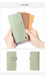 Détail d'un porte-cartes en cuir grainé vert menthe avec plusieurs fentes et pression