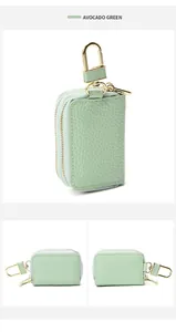 Detailopname van avocado groen sleuteltasje van leer met goudkleurige hardware