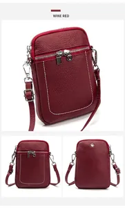 Dettaglio della borsa porta cellulare in pelle bordeaux con cuciture bianche e fibbie