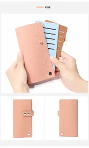 Détail du porte-cartes en cuir rose avec fentes verticales et fermoir à bouton-pression