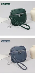 Dettaglio di portafogli in pelle verde scuro e blu denim con zip e cinturini