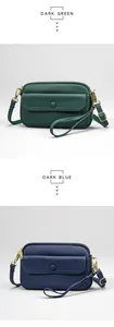 Detail of dark green and dark blue pebbled leather bags with gold-tone hardware